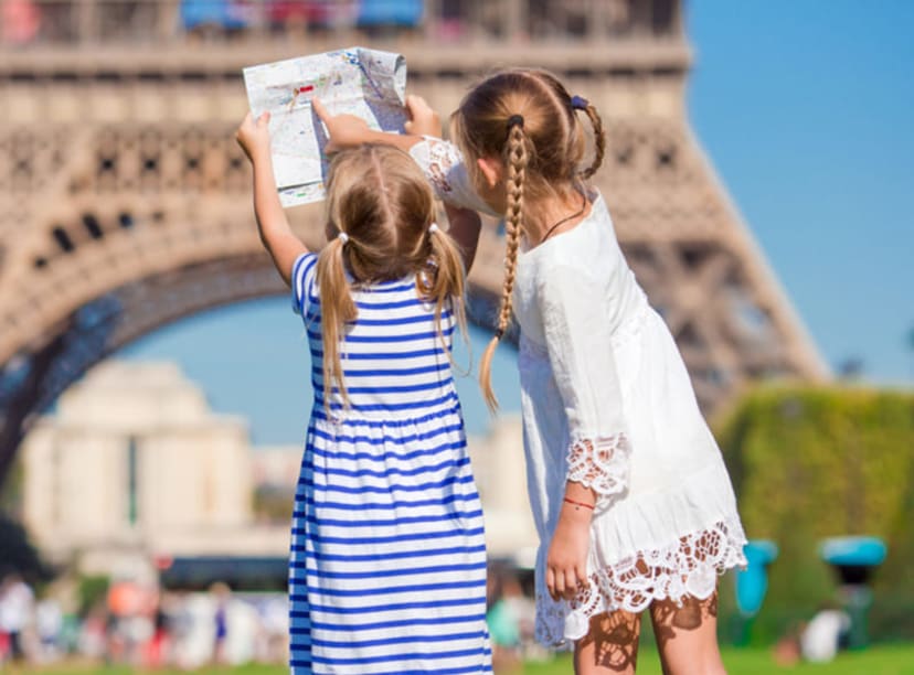 Children looking at a map by the Eiffel Tower