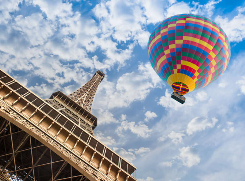 A hot-air balloon passes by the Eiffel Tower