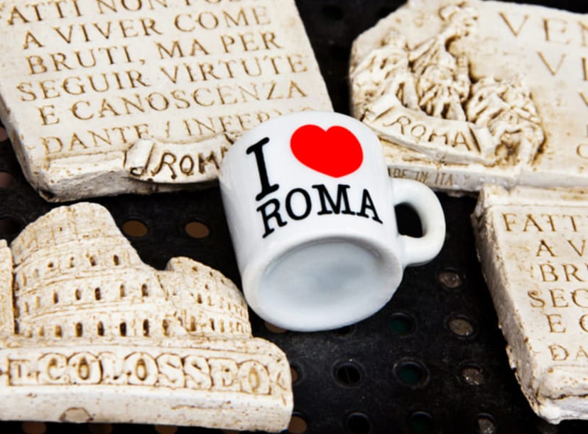 Souvenirs of Rome, including a mug and fridge magnets of the Colosseum and Latin script