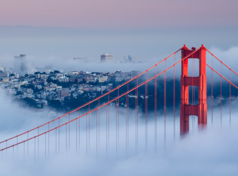 Tip of the Golden Gate Bridge peaking out above a cloud of fog