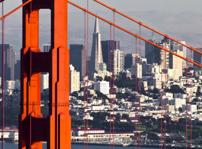 San Francisco skyline captured through the suspension cables of the Golden Gate Bridge