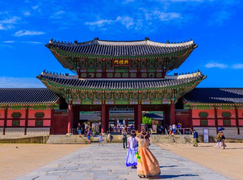 Koreans in traditional dress at the entrance to Gyeongbokgung Palace in Seoul.