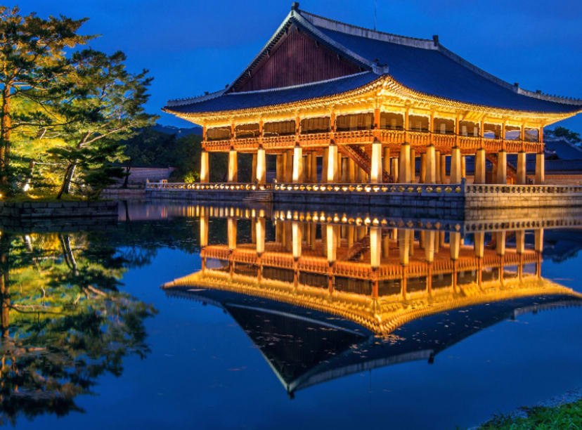 Pavilion in Seoul lit up at night and reflecting in the water