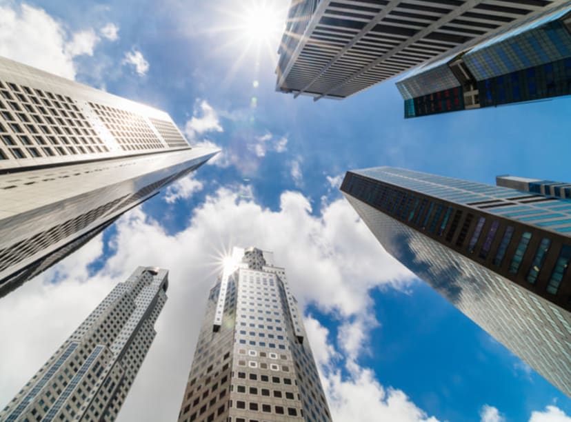 View looking upwards at skyscrapers in Singapore's CBD on a sunny day.