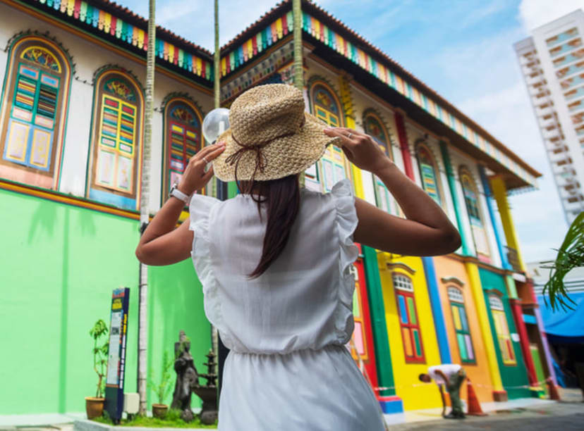 Woman exploring colorful buildings in Singapore's Little India neighborhood