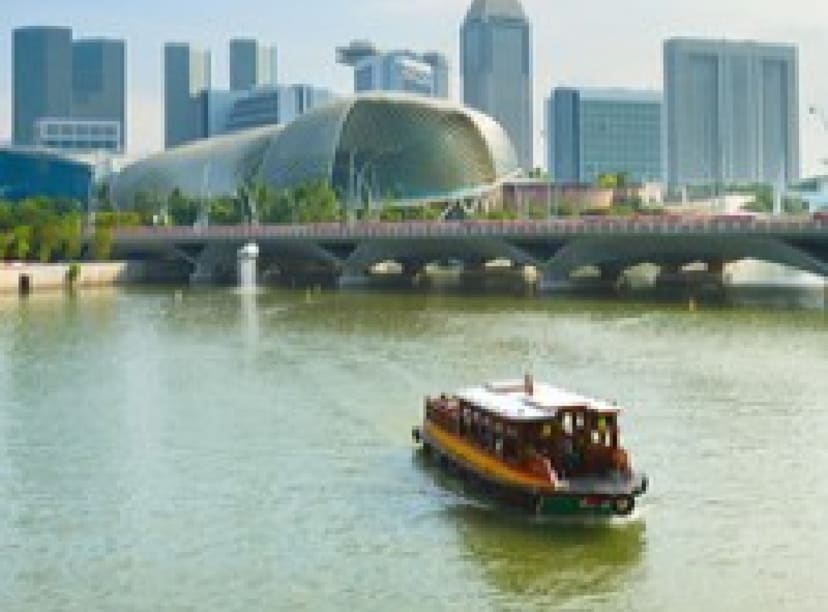 Traditional boat on the Singapore river with skyscrapers in the background