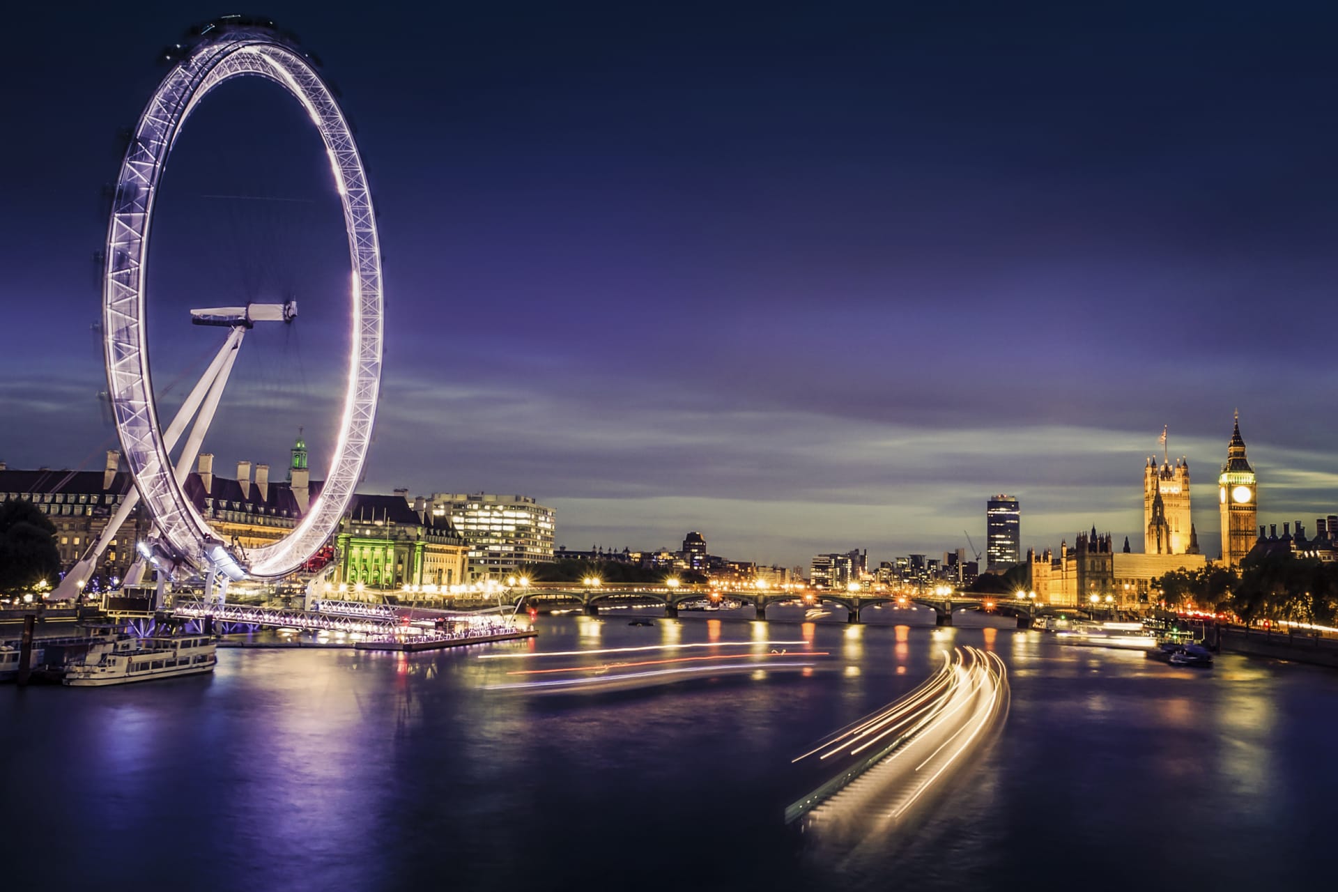 Barcos del Támesis, London Eye y el Big Ben iluminados por la noche. Cosas que hacer en Londres por la noche.