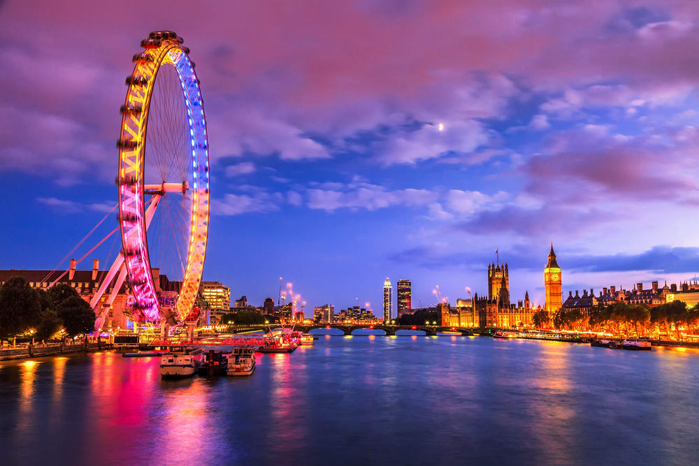 Vista nocturna del Támesis, con el London Eye y el Big Ben iluminados. Londres para parejas.