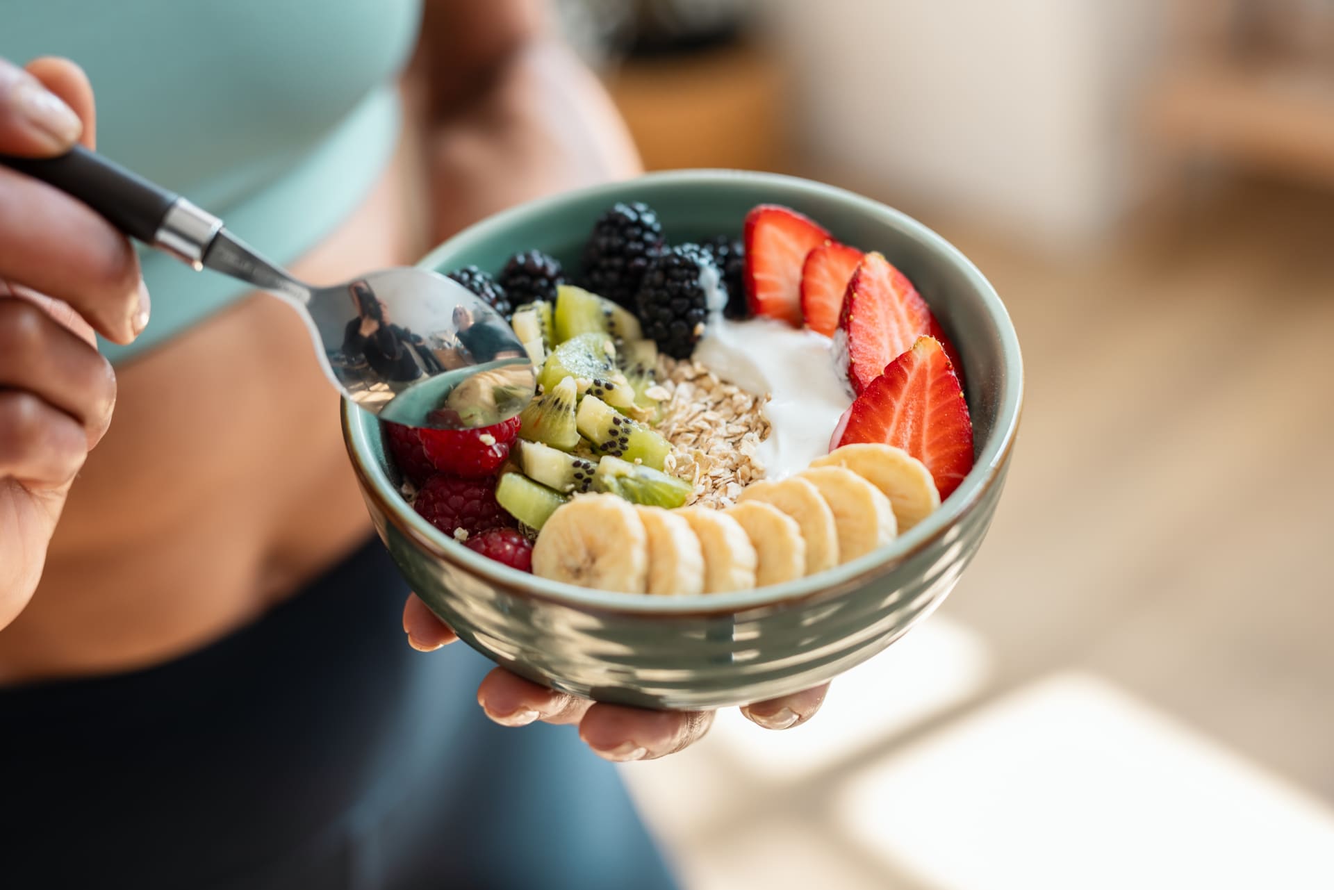 close-athletic-woman-eating-healthy-fruit