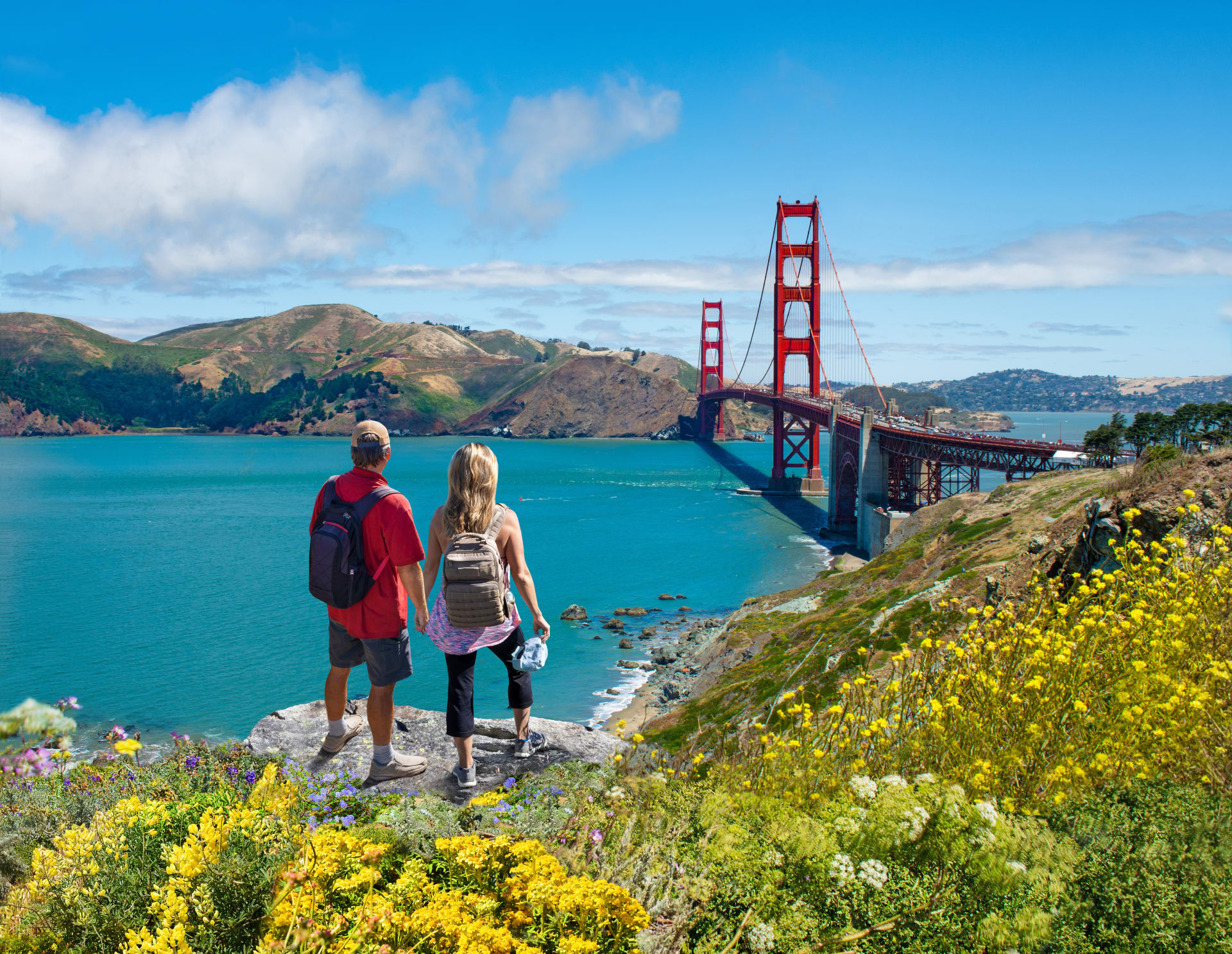 couple-holding-hands-looking-golden-gate-bridge
