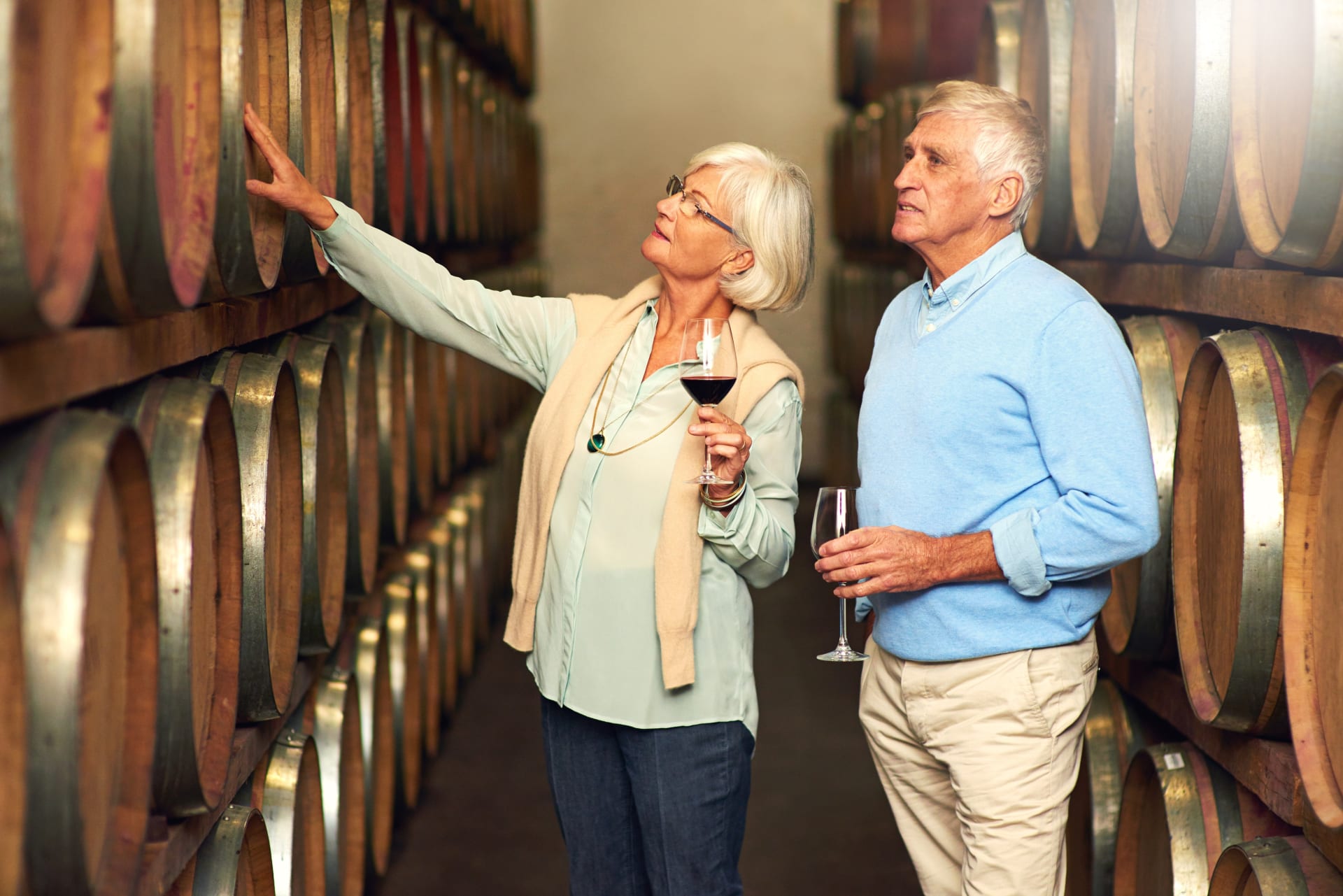 Couple Looking at Wine Barrels 