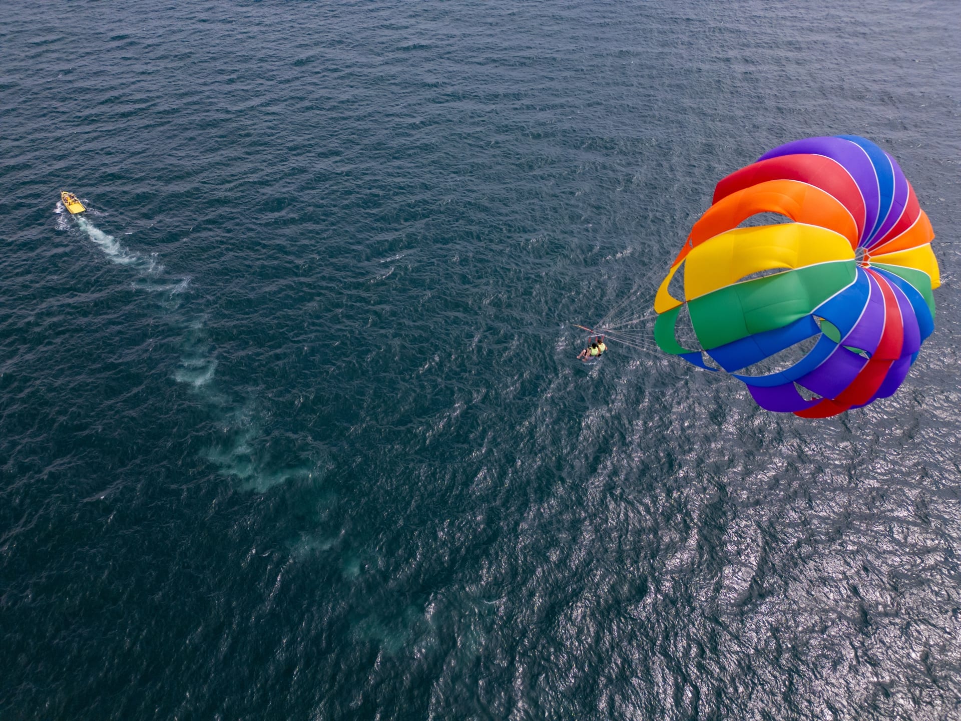 Persona hace parasailing en el mar del Caribe. Qué hacer en Cancún en invierno.