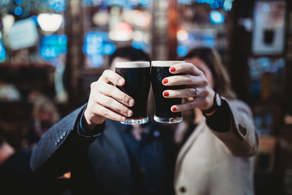 Pareja brinda con Guinness en un pub de Dublín, Irlanda. Dublín para estudiantes.