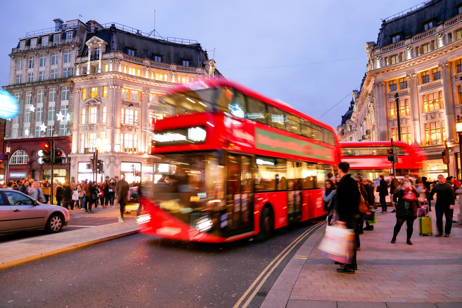 Vista de Oxford Street al atardecer, con autobús de dos pisos y gente en la calle, Londres. Planes nocturnos en Londres.