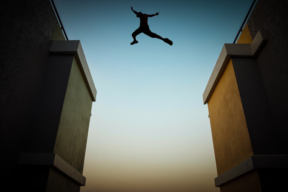 Parkour enthusiast leaping between buildings