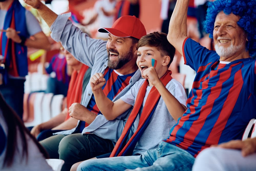 Family of sports fans cheering on their team in a stadium