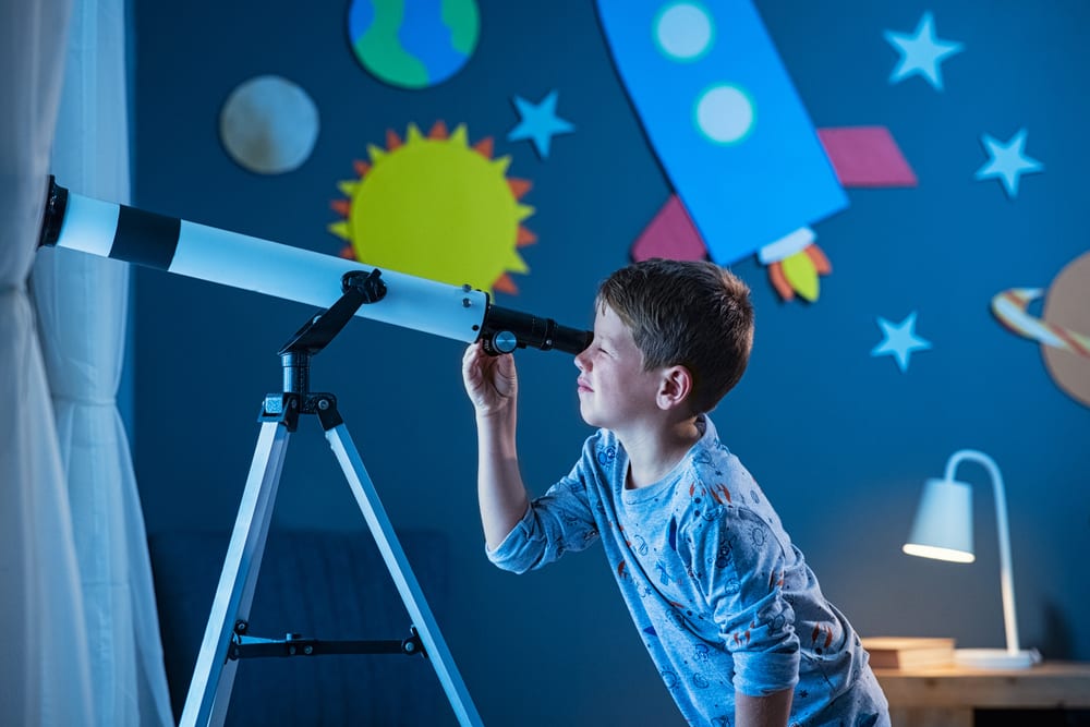 Child looking through a telescope