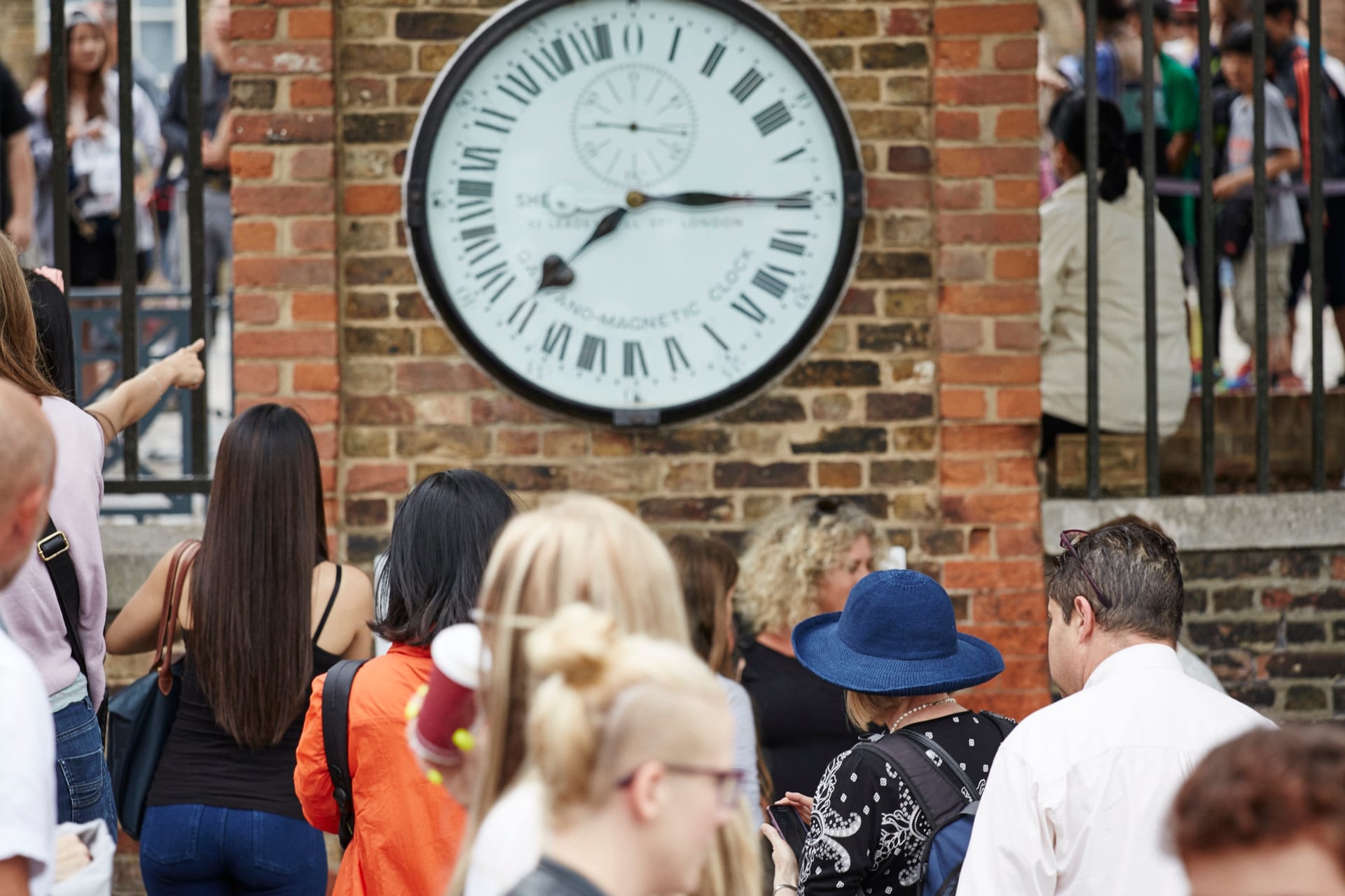 un reloj en el Real Observatorio de Greenwich con visitantes
