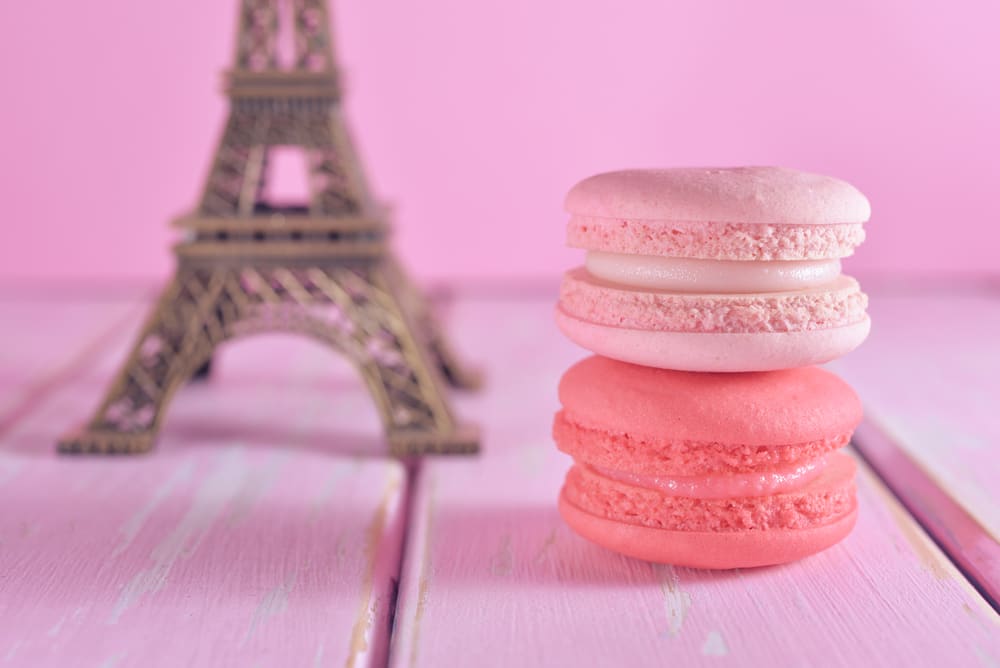 Pink macarons beside an Eiffel Tower ornament
