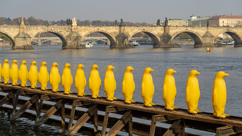 Museum Kampa's yellow penguins against the backdrop of Charles Bridge in Prague