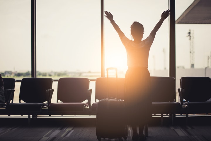 Mujer feliz en el aeropuerto de Roma al amanecer. Opciones de traslado privado a Roma desde el aeropuerto.