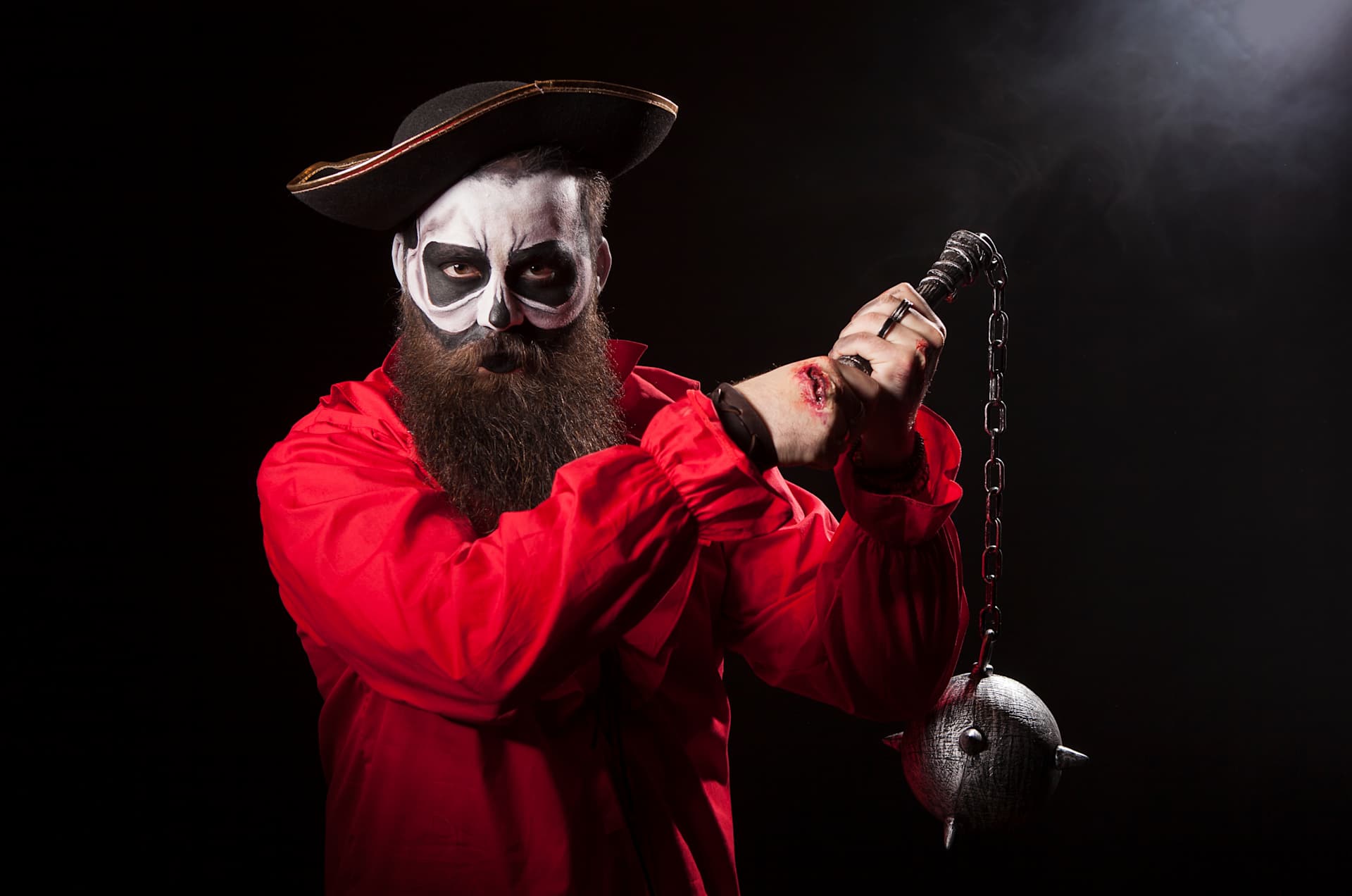 actor in dark makeup holding a medieval mace