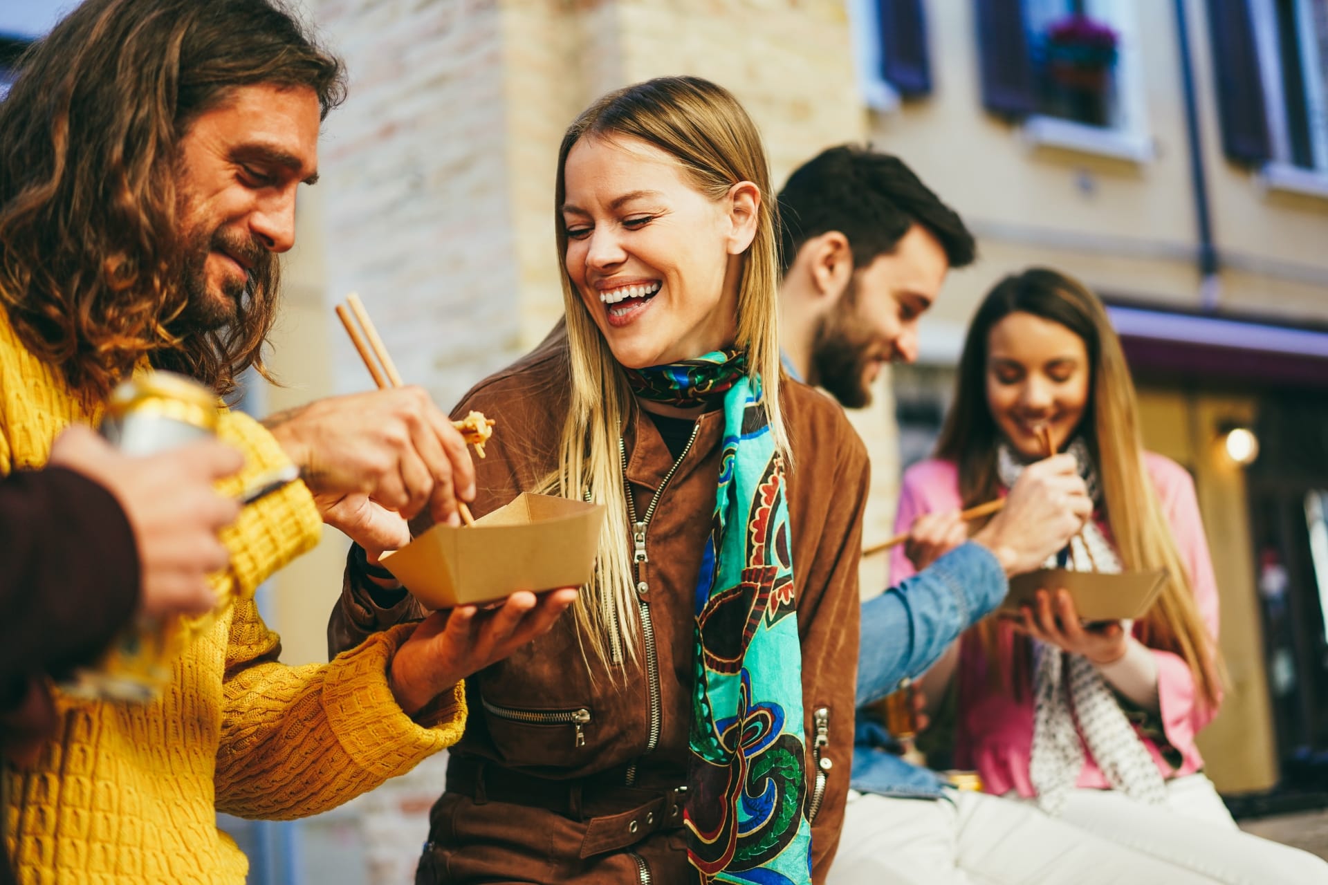happy-young-friends-eating-takeaway-food