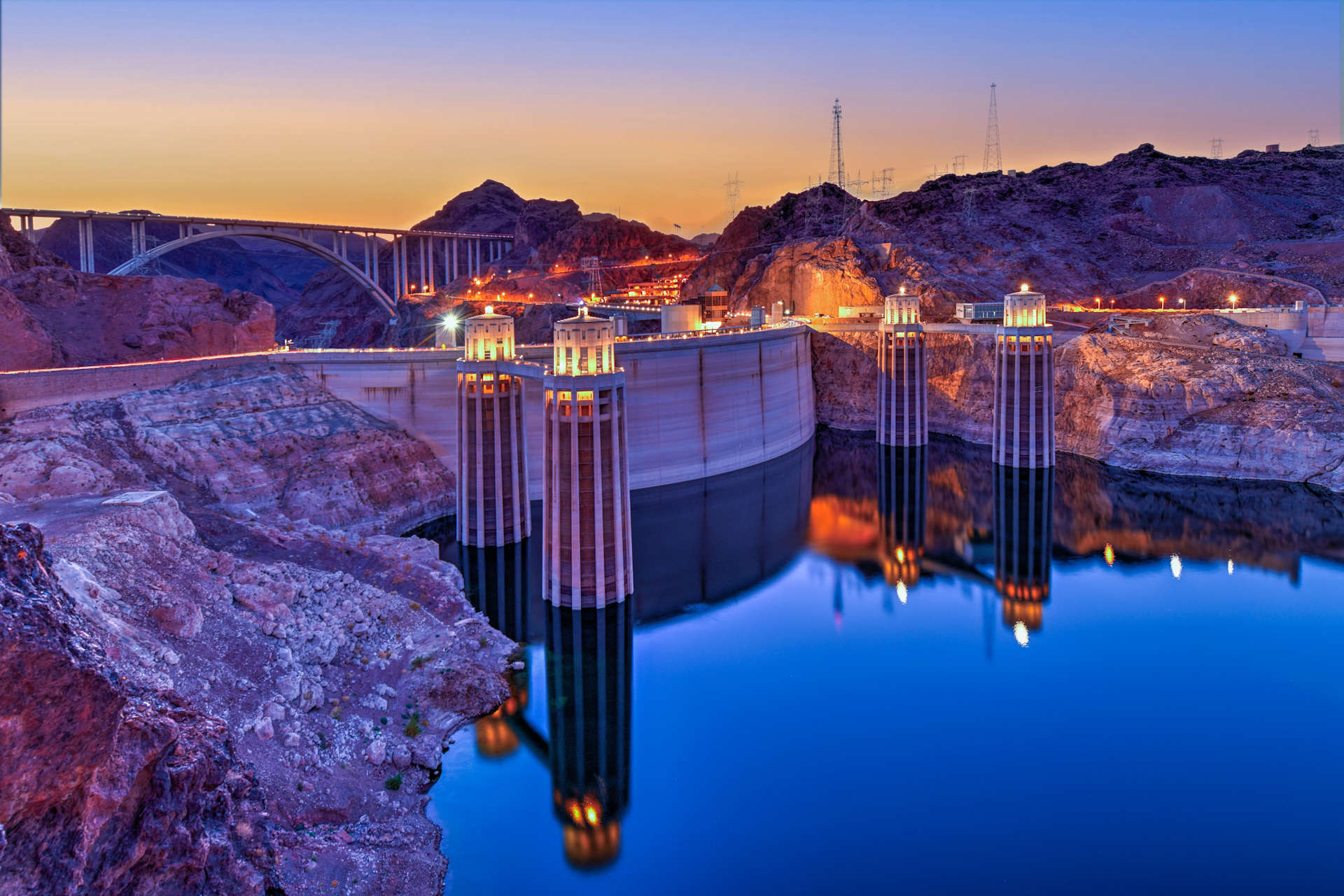 hoover dam lit up at dusk