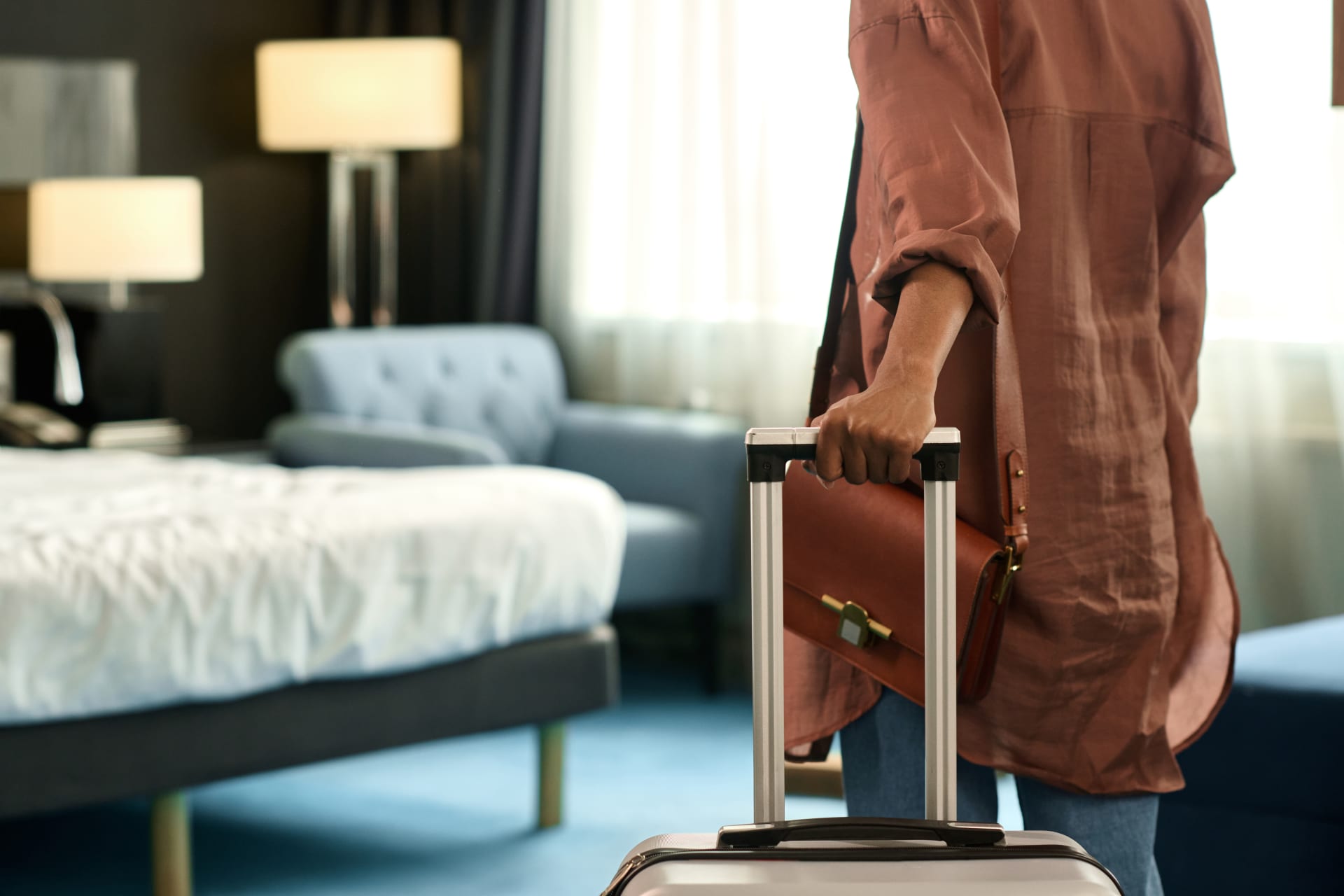 Woman arriving in hotel room with suitcase