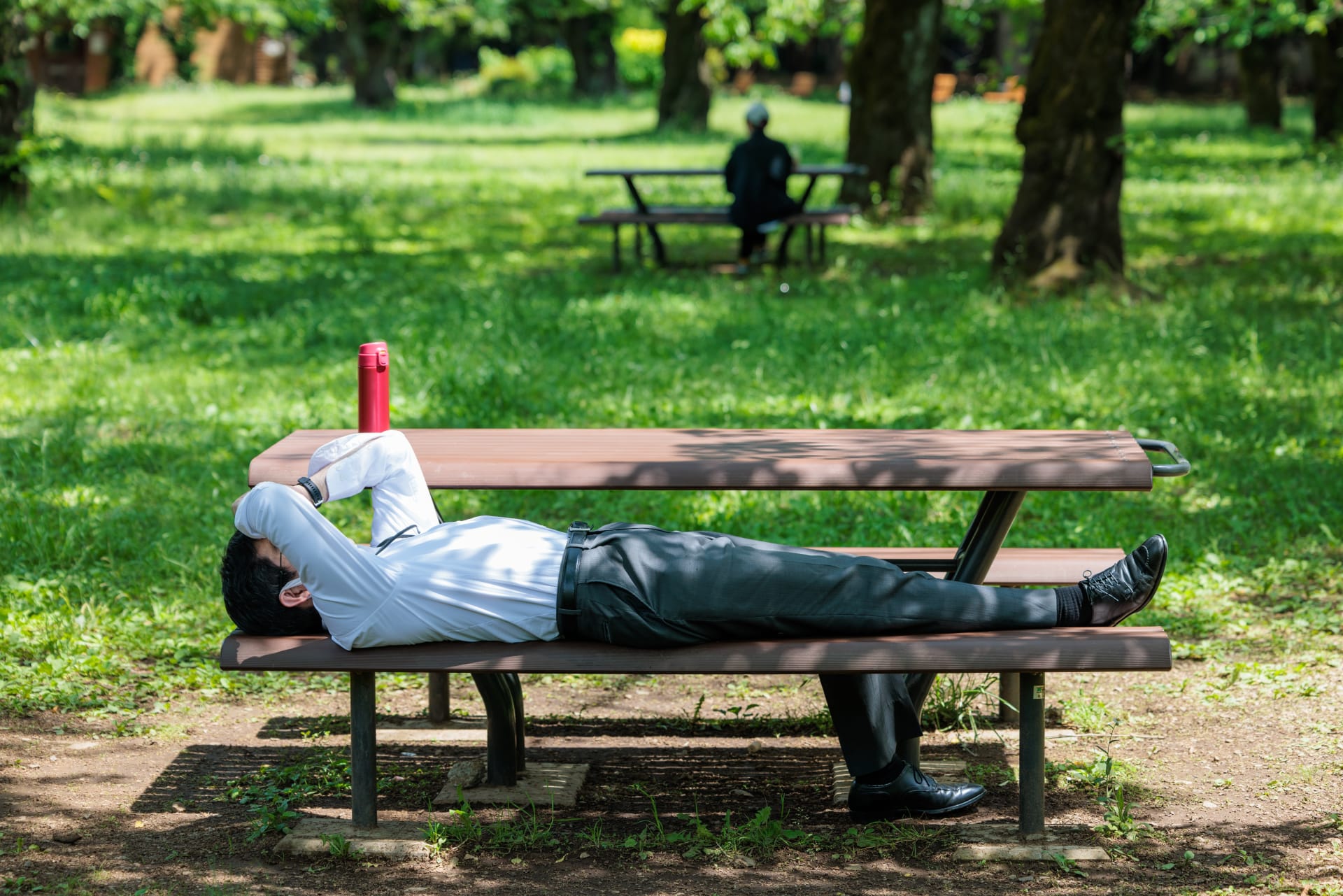 man-taking-nap-park-during-lunch