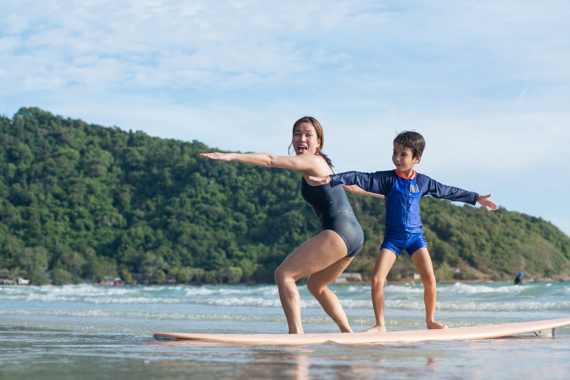 母亲在冲浪课上教儿子基本功