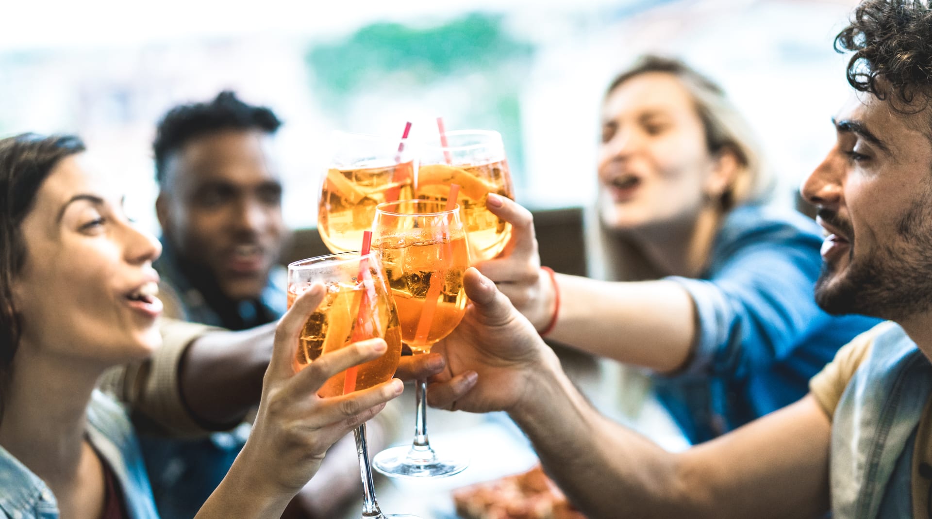 Gente brindando con spritz alrededor de una mesa. Barrio de Little Italy en Nueva York.
