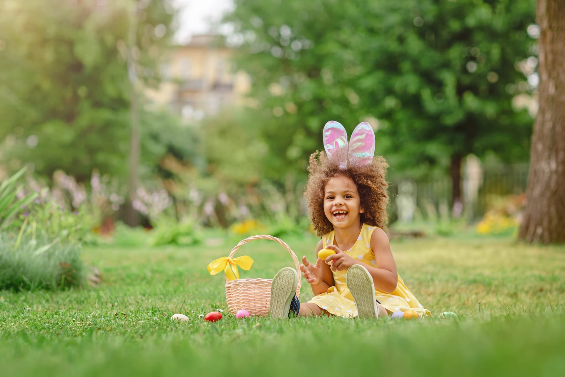 Child wearing bunny ears on an Easter egg hunt in the park