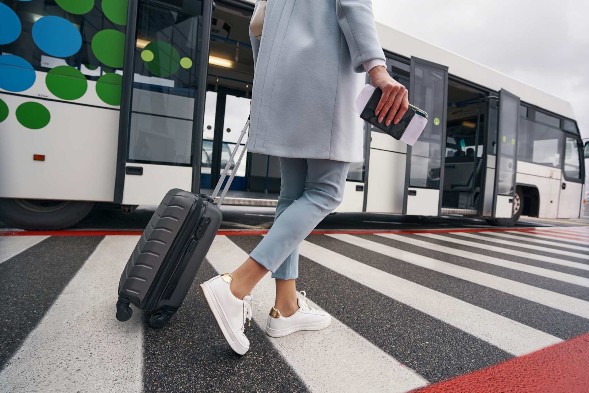 a woman boarding a shuttle bus with her luggage