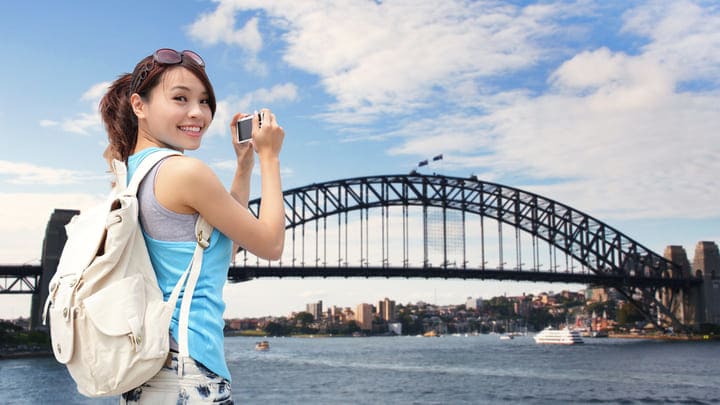 Woman photographing Sydney Harbour Bridge