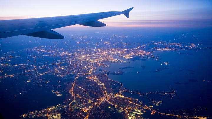 Vista de Boston de noche desde un avión. Medios de transporte desde el aeropuerto a Boston.