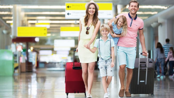 Happy young family walking through the airport