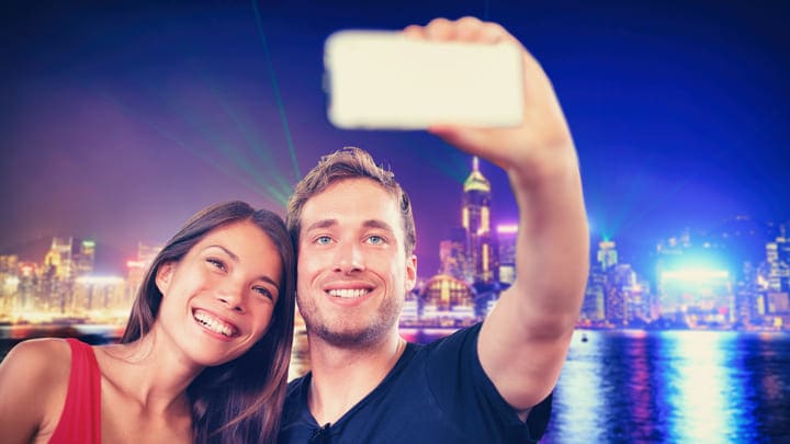 Couple taking a selfie on Tsim Sha Tsui Promenade in Hong Kong