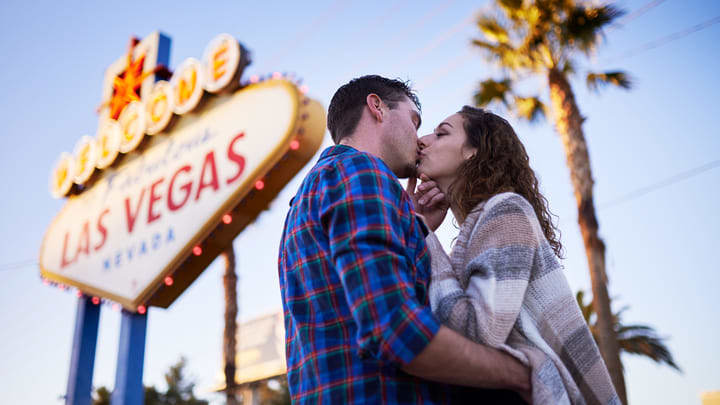 Couple kissing at the 'Welcome to Fabulous Las Vegas' sign