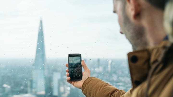 Man taking a photo of The Shard on his phone