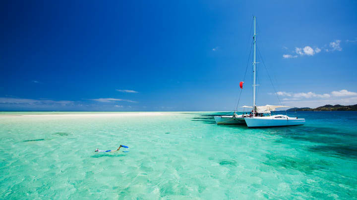 Catamaran at a snorkeling spot in clear tropical waters