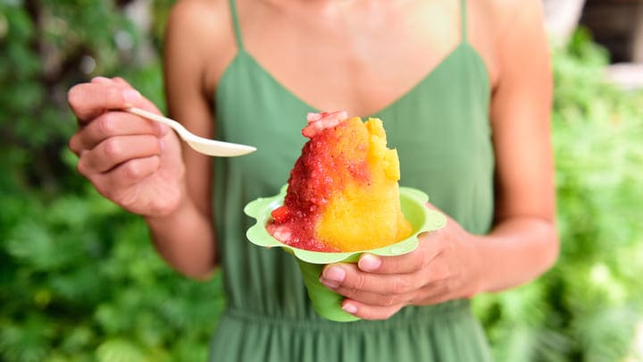 Woman holding tub of colorful shave ice