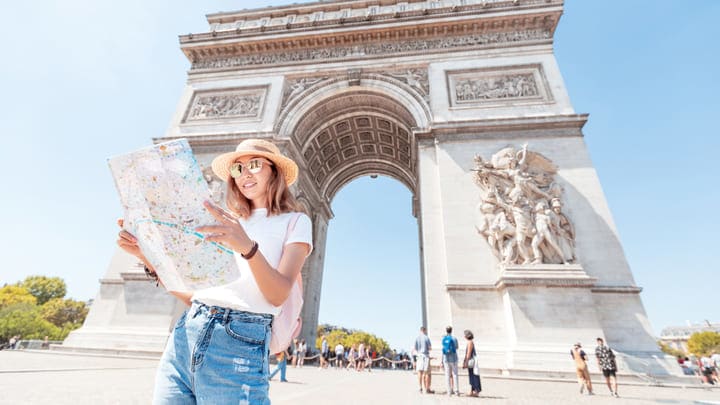 Woman reading a map by the Arc de Triomphe in Paris