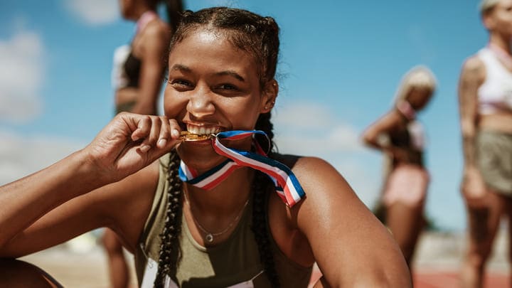 Atleta mordiendo la medalla. Sedes olímpicas en los alrededores de París.