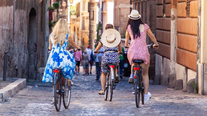 Mujeres montando en bici por las calles de Roma. La mejor época para disfrutar de Roma.