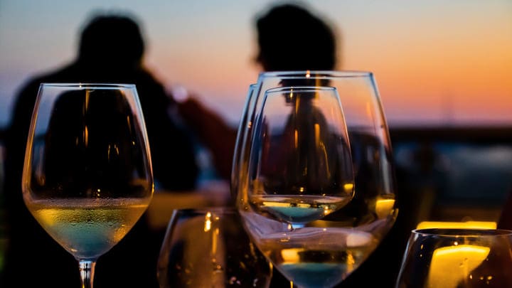 Couple drinking wine in a bar at sunset