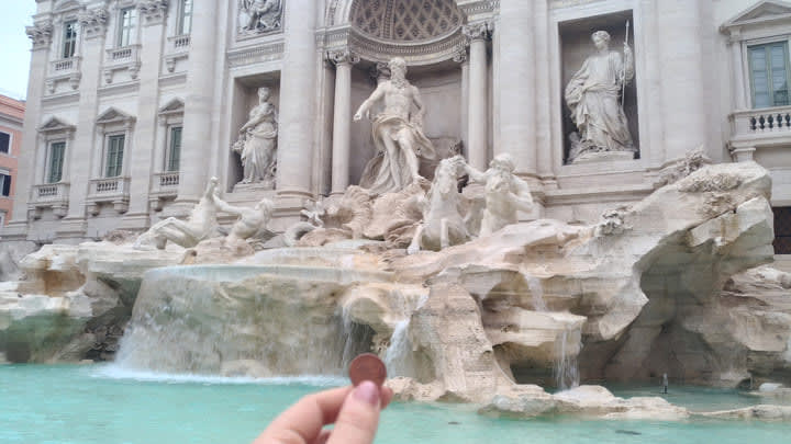 Throwing a coin into the Trevi Fountain