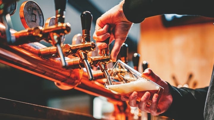 Bartender pouring beer from taps
