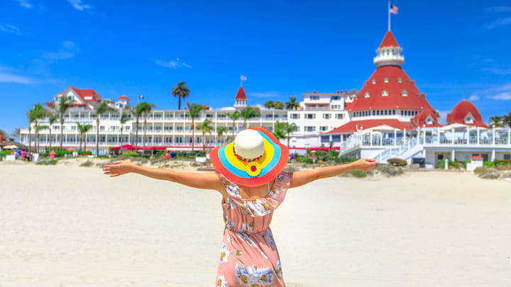 Woman in a summer dress in front of Coronado Island's iconic Hotel del Coronado