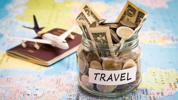 Travel savings pot on a map with a toy aeroplane